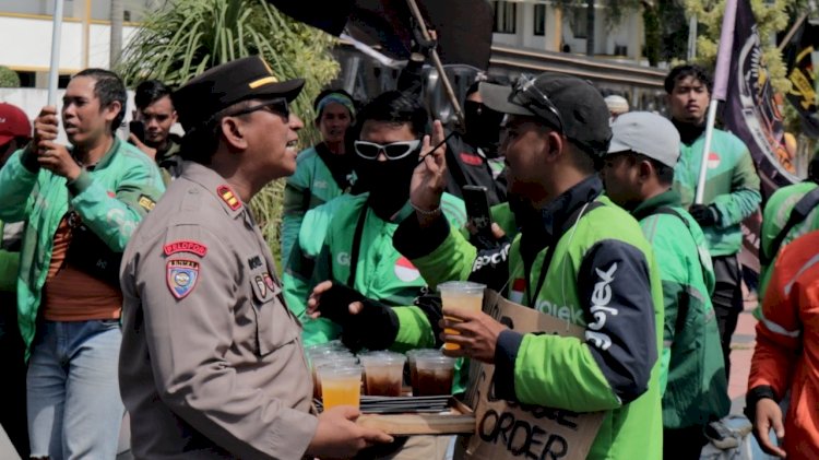 Humanis Polisi Kawal Aksi Damai Driver Ojol di Jember Sambil Berbagi Minuman Dingin